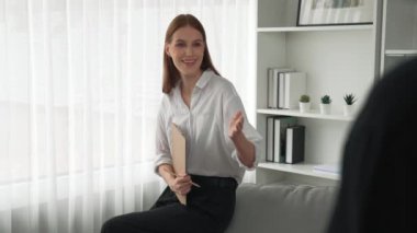 Klinikteki psikolog kadın. Profesyonel portresi. Dostane gülümsemesiyle hastayı psikoloğa davet ediyor. Tecrübeli ve kendinden emin psikolog.