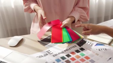 Grafik tasarımı için renk seçimi yapan ve beyin fırtınası yapan iki tasarımcının yavaş çekim çekimi ya da tasarım bürosunda kromatik danışmanlık hizmeti isteyen bir müşteri. Değiştirilmiş