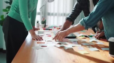 Dizüstü bilgisayara bakan ve logo tasarımını işaret eden yetenekli bir iş ekibi ana tema rengini seçme ve pazarlama kampanyasını planlama kararı alıyor. Birlikte çalışan akıllı bir grup. Sempozyum.
