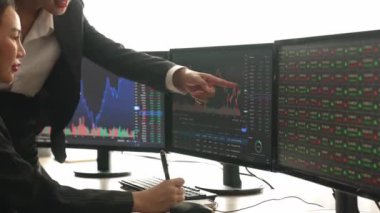 Menkul kıymetler borsası pazarlamasını inceleyen borsa yatırımcıları, zarar ve kazanç için mum bar fiyatlarını analiz eden monitörlere bakıyor. Filizlenen