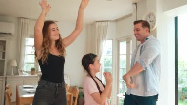 Mutlu aile portresi, gülümseyen sevimli küçük bir kız, sevimli ve neşeli bir ebeveyn ve kızlarıyla birlikte sıcak gün ışığıyla birlikte oturma odasında oturuyorlar. Titiz