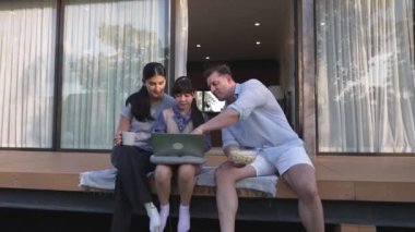 Şirin baba, anne ve kızı birlikte evin bahçesinde oturuyorlar. Ebeveynler, çevre farkındalığıyla ilgili genç nesli iletişim kurmak için açık hava aktivitelerini kullanırlar. Uyumsuzluk.