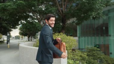 Keyifle dans eden yetenekli beyaz iş adamı soğukkanlılığını koru ve şehir merkezinde yürümeye devam et. Profesyonel menajer terfi ile ilgili iyi haberleri kutlamak için dans ediyor. Sevinçli..