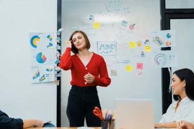 Profesyonel çekici kadın lider, modern iş toplantı odasında beyin fırtınası zihin haritalama istatistikleri ve renkli yapışkan notlar kullanarak yaratıcı pazarlama planını sunuyor. Tertemiz..