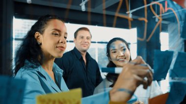 Profesyonel iş adamlarının portresi. Cam tahtaya yapışmış renkli yapışkan notlar üzerinde pazarlama fikri. İspanyol proje yöneticisi not olarak iş stratejisi yazdı. Yönlendirici.