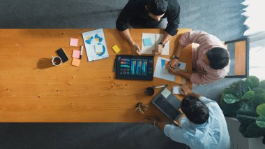 Yönetici, toplantı odasındaki meslektaşlarına mali grafiği açıklar. Farklı pazarlama ekibinin tabletle masada otururken fikir ve planlama stratejisini en üst düzeyde paylaşması. Cemaat.