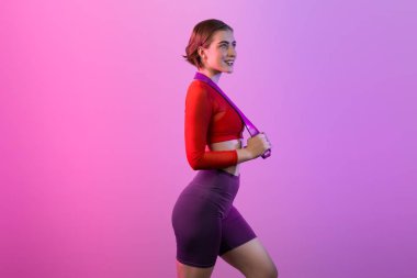 Vücut uzunluğunun tamamı atletik ve sportif, elastik direnç bandıyla izole edilmiş arka planda duran genç bayanı çekiyordu. Sağlıklı aktif ve vücut bakımı yaşam tarzı.