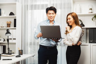 Gülümseyen Asyalı iş arkadaşları modern ofiste dizüstü bilgisayar pazarlama projesi hakkında konuşurken. Yeni sosyal medya kanalında başarılı müşteri ihtiyaçları analiz ediliyor. İnfobahn.