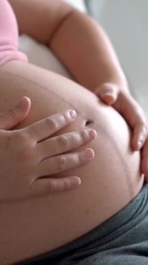 Hamile bir kadın çocuğuna bakarken kendini mutlu hissediyor. Hamile karnında bebek taşıyan hamile bir anne. Doğum öncesi bakım ve kadın hamileliği konsepti.
