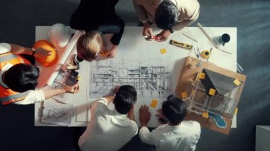 Becerikli mühendis ekibinin ev inşaatından bahsedişinin en alt görüntüsü. Mimar ya da tasarımcı grubunun planlar hakkında beyin fırtınası yapmak için tartışan ve yazan hava görüşü. Hizalama.