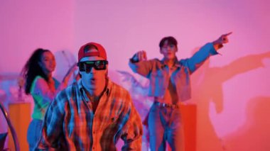 Profesyonel break dansçı neon ışıkla sokak dansı yapar ve pratik yapar. Kafkasyalı adam enerjik hareketler sergilerken mutlu bir takım hip hop müziğine geçiyor. Mutluluk.