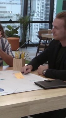 Yaratıcı iş adamları modern işyerindeki ofis masasında sohbet ediyorlar. Şirket uluslararası iş kavramı.