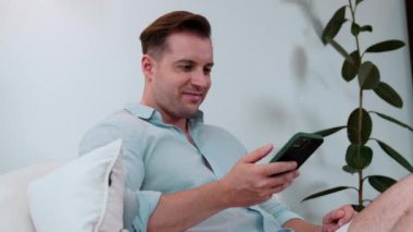 Orta yaşlı bir adam oturma odasındaki koltukta oturur telefon arama verilerini kullanır çocukları iyi bir yetişkin baba ya da eğlence olarak yetiştirir. İşadamı teknolojiyi kolaylık için kullanır. Uyumsuzluk.