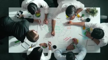 Yetenekli iş adamlarının zihin haritası kullanarak beyin fırtınası yapmak için birlikte çalışmaları zaman aşımı. Yetenekli yöneticinin sürdürülebilir enerji hakkında konuşup tartışmasının havadan görüntüsü. Hizalama.