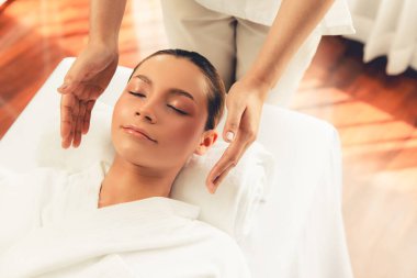 Kafkasyalı kadın stres önleyici kafa masajından ve lüks tatil beldesi ya da otel spa salonundaki modern ışık ortamında yüz güzelliği eğlencelerini şımartmaktan hoşlanıyor. Sessiz.