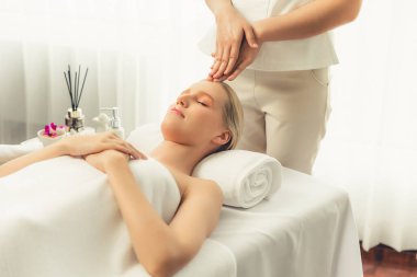 Kafkasyalı kadın stres önleyici kafa masajından ve lüks tatil beldesi ya da otel spa salonundaki modern ışık ortamında yüz güzelliği eğlencelerini şımartmaktan hoşlanıyor. Sessiz.