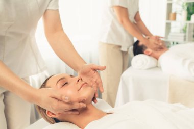 Kafkasyalı çift stres önleyici kafa masajının keyfini çıkarıyor ve lüks otellerde ya da otel spa salonlarında gündüz kaplıcalarında yüz güzelliği eğlencelerini şımartıyor. Sessiz.