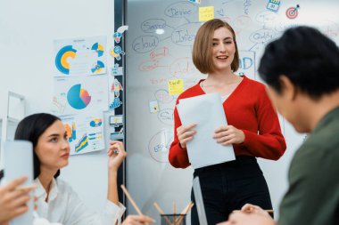 Profesyonel çekici kadın lider, modern iş toplantı odasında beyin fırtınası zihin haritalama istatistikleri ve renkli yapışkan notlar kullanarak yaratıcı pazarlama planını sunuyor. Tertemiz..
