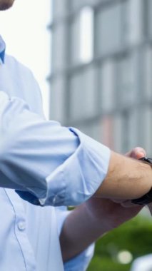 İş adamı, şarj istasyonundan şarj olurken akıllı hareketten hologramda EV akü durumunu kontrol ediyor. Modern şehir yaşam tarzı ve karbondioksiti azaltmak için çevre dostu elektrikli araba kullanımı. İnceleyin