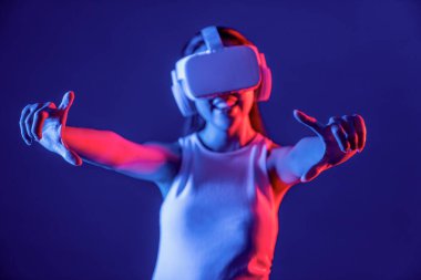 Meta-evren, gelecekteki siber uzay topluluğu teknolojisini bağlayan neon ışıklı kulaklıklarla çevrili bir kadın standı, hem el indeksi hem de başparmak parmağı etkileşimli sanal nesne kullanır. Halüsinasyon.