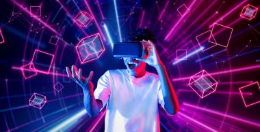 VR gözlük takan zeki bir genç ve geometrik şekil konusunda heyecanlı. Afrikalı oyuncu gündelik kıyafet giyiyor ve artırılmış gerçeklik teknolojisi kullanırken parlak ışık rengiyle çevrili. Yaratıcılık.