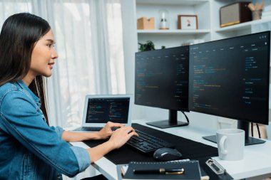 İnternet sitesi uygulamasının kodlama verileriyle birlikte online bilgi yazarak kot gömlek giyen genç Asyalı geliştirici. Güvenlik analizi ile çevrili iki ekran. Taktik.