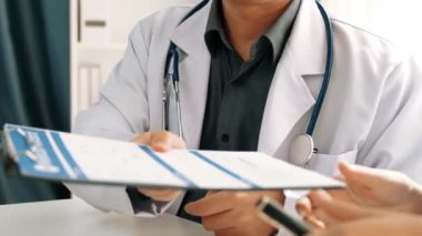 Hastane masasında birlikte çalışan ve tıbbi tedavi planlayan çeşitli profesyonel sağlık görevlileri. Takım çalışması başarılı hastalıklara ve hastalıklara yol açar. Ağır çekim. Katı.