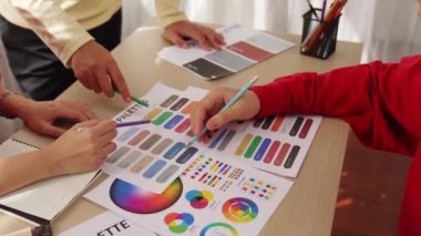 Grafik tasarımı için beyin fırtınası yapan ve renk seçimi yapan tasarımcı ekibinin yavaş çekim çekimi veya tasarım bürosunda krom danışmanlığı için danışmanlık isteyen bir müşteri. Değiştirilmiş