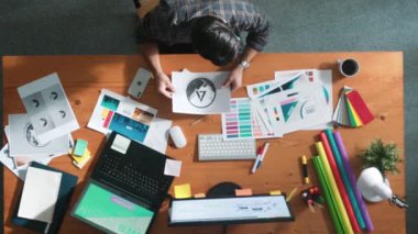 Akıllı iş adamının logo grafiği tasarlarken renk paletleri seçmesinin üst görünümü. Profesyonel iç mimar tasarımının hava görünümü ve renk paletleri kullanarak renk temasını seçin. Sempozyum.