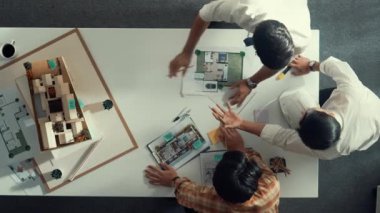 Bir grup yetenekli tasarımcı inşa hakkında tartışırken modele bakıyor. Mimar mühendisin üst görüşü, toplantı masasında konuşurken ve yazarken fikri açıklıyor. Hizalama.