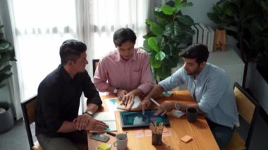İş adamının toplantıda tabletten finansal grafiğe bakması ve analiz etmesi. Bir grup insan yapışkan notlar kullanarak bir not alırken beyin fırtınası ve planlama stratejisi yapıyor. Cemaat.