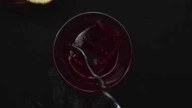 Barmen el yapımı ve siyah arkaplanlı Scarlet Spritzer 'ı hazırlayın. Limon dilimli kırmızı kokteyli sunan ve hazırlayan akıllı barmen elleri yakın plan. Geliştirilebilir.