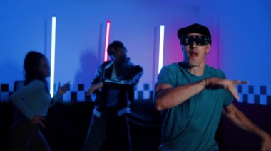 Kameranın önünde dans eden yetenekli break dansçı farklı arkadaşları pop ya da hip hop müziği dinlemek için arkada dans ediyor. Çekici performans ekibi kameraya doğru hareketli hareketler sergiliyor. Mutluluk.