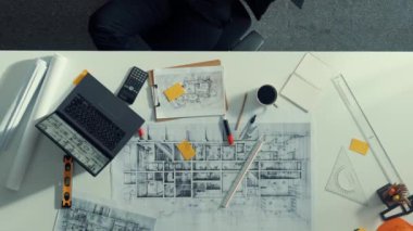 Gevşemiş akıllı inşaat mühendisinin en iyi görüntüsü mola zamanında planlarla birlikte masada uzanıyor. Dizüstü bilgisayar ve ekipman üzerinde çalıştıktan sonra uyuyan mühendisin hava görüntüsü. Hizalama.