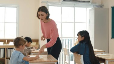 Sınıfta çeşitli çocuklar sınıf ödevlerini yaparken, Kafkasyalı öğretmen sınıfta yürüyor ve öğrenci ödevlerini kontrol ediyor. Çeşitli zeki öğrenciler ilkokulda ders veriyor ve not alıyor. Pedagoji.