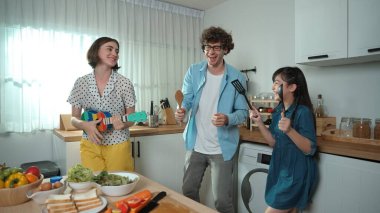 Mutlu baba yemek pişirirken müziğe geçiyor ve modern mutfakta öğle yemeği hazırlıyor. Aktif baba, sebze ve mutfak gereçleri ile çevrili sağlıklı yemek ya da salata yaparken şarkıyla dans ediyor. Pedagoji.