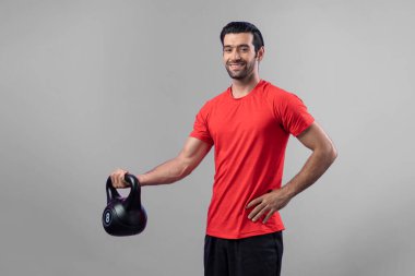 Vücut geliştirme egzersizi için ağırlık kaldırmak için kettlebell kullanan atletik ve sportif bir adam izole edilmiş arka planda ayakta duruyor. Sağlıklı aktif ve vücut bakımı yaşam tarzı
