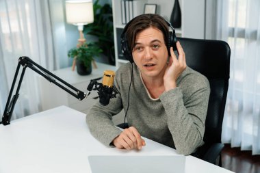 Sunucu kanalı, gülümseyen akıllı yayıncı kaydı, senaryosu ve akıllı telefonuyla sosyal medyada sohbet programı, kulaklık takarak modern ev stüdyosundaki video flamalarını kaydediyor. Bireysel.