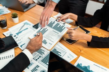 Ofis masasındaki finansal veri raporlarını analiz eden çeşitli bir grup iş analisti. Stratejik pazarlama planlaması için iş istihbarat analizine göre grafikler ve grafikler.