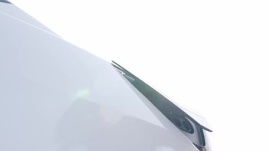 Yavaş çekim yakın çekim adamı, şehir merkezinin otoparkındaki şarj istasyonundan elektrik aküsünü şarj etmek için EV şarj aleti koydu.