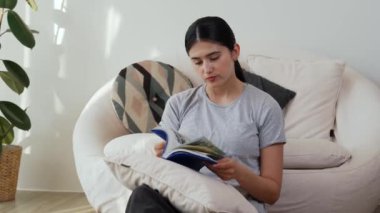 Kanepede oturan orta yaşlı bir kadın, sosyal ve teknolojik mesleki gelişmeler hakkında ders kitabı okur ya da zeki bir anne olmak için çocuk yetiştirir. Hayat boyu öğrenme konsepti. Uyumsuzluk.