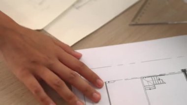 Ölçüm ve yazma aracını kullanarak mimari ofisindeki inşaat doğruluğu için ayrıntılı bir plan tasarlayan akıllı mimar ya da akıllı mühendisin videosu. Eline odaklan. - Yakın çekim. Tanımlama.