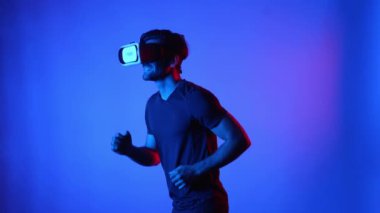 Meta evren egzersizi yaparken VR gözlüğü takan beyaz bir adam. Sanal gerçeklik ya da gelişmiş gerçeklik teknolojisi kullanarak atlet koşuyor. Spor konsepti. Eğlence için. Aygıt.