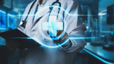 Tıbbi haç hologramına işaret ederken elinde tablet olan doktorlara yaklaş. Profesyonel pratisyen hekimin holograma tıklaması ve teşhis koymak için tıbbi verilere erişmesi. İyileştirici.