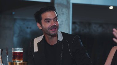 Barmen, dumanlı klasik viskiyi kokteyl ile karıştırıyor. Bir bayana içki tadıyor ve kulüpteki grup misafirlerine içecek tezgahında lezzetli bir içki ikram ediyor. Vinosity.