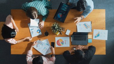 Proje yöneticisinin veri ve mali tabloyu analiz etmek için tablet kullanırken pazarlama ekibinin pazarlama kampanyası ya da toplantı odasında planlama stratejisi üzerinde birlikte çalışmasının en üst görüşü. Cemaat.