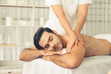 Kafkas erkek müşteri stres önleyici spa masajının keyfini çıkarıyor ve lüks otel veya oteldeki gündüz açık hava ortamında güzellik derisi eğlencesi ile şımartıyor. Sessiz.