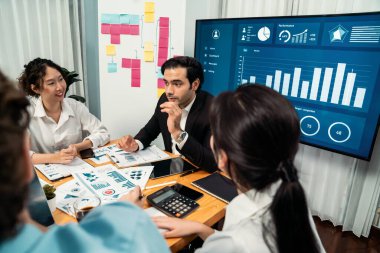 Finansal veri raporunu analiz eden çeşitli bir grup iş analisti. Mali veri analiz çizelgesi ve grafik paneli stratejik pazarlama planlama için toplantı odasında TV ekranında. Habiliment