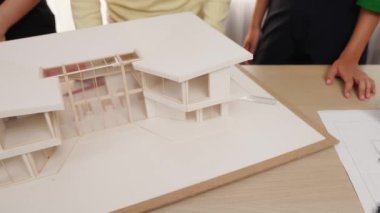 Mimari ekipman kullanarak yavaş çekim ev tasarımcısı bir plan çizerken, iç mimari tasarımcı da müşterilerin talebine göre renk örneklerinden uygun renkler seçiyor. Değiştirilmiş