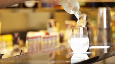 Yakından bir barmen, bir şişe taze gazlı gazlı içeceği bir bardak dolusu müşteriye dönüştürüyor. Lüks karşılama klübünde içecekleri yudumlamak için lüks bir karşılama hizmeti sunuyor. Vinosity.